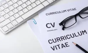 Klawiatura, okulary i dokumenty CV na białym tle.