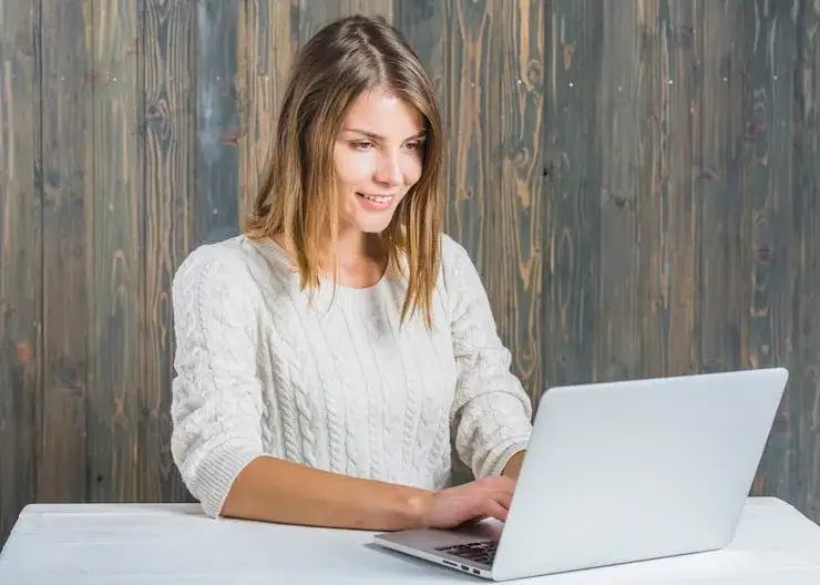 Młoda osoba szukająca pracy na laptopie z ikonami portali rekrutacyjnych